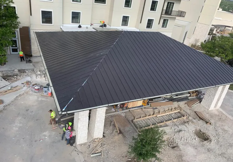 Metal roofing installation team working on a commercial building in Holly Hill